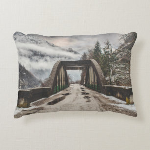 GRAY CONCRETE ARCH BRIDE BESIDE LEAFLESS TREE NEAR ACCENT PILLOW