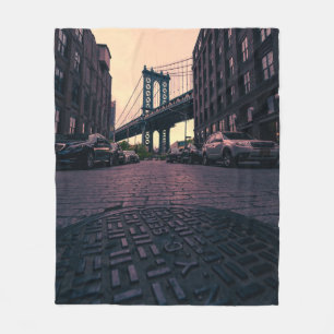 GRAY VEHICLE AT ROAD BESIDE CONCRETE BUILDING FLEECE BLANKET