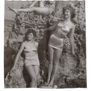 GRAYSCALE PHOTO OF THREE WOMEN STANDING AND SITTIN