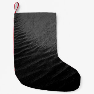 Grayscale photography of sand small christmas stocking