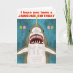 Great White Shark Funny Jawsome Birthday Pun Humou Card<br><div class="desc">The Great White Shark on this funny greeting card is so kind. See? It's smiling and hoping you have a jawsome birthday. It even brought balloons and is balancing a candle on its nose. The design includes a hand-drawn shark on a blue / sea green background with the silhouettes of...</div>