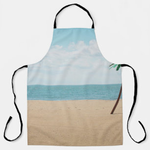 Green artificial palm tree on seashore apron