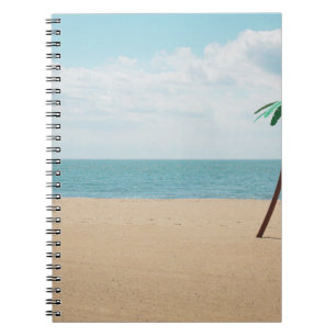 Green artificial palm tree on seashore notebook