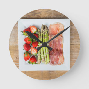 Green asparagus with ham and strawberries round clock