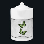 Green Butterfly Floral Teapot<br><div class="desc">Enjoy your tea with a Green Butterfly Floral Personalized Teapot. Teapot design features a pair of vibrant butterflies resting on a white floral vine against a light grey grunge background. Additional gift items available with this design as well as a variety of colours.</div>