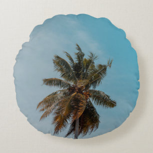 Green coconut tree under blue sky round pillow