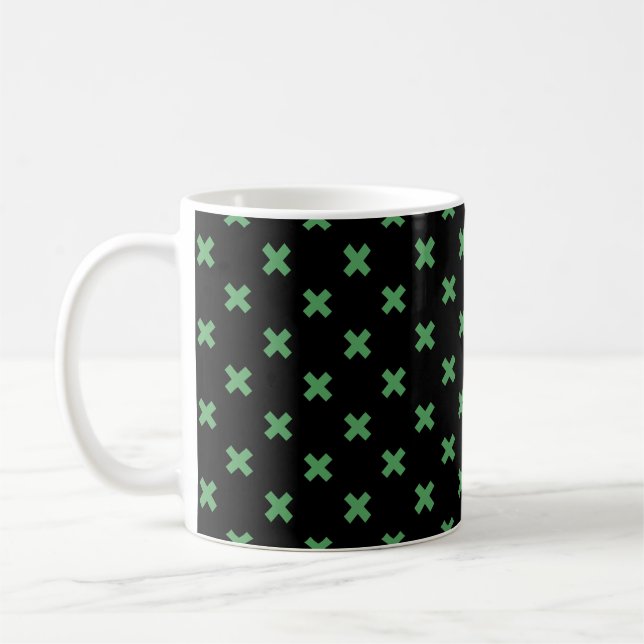 Green cross stitches on black coffee mug (Left)