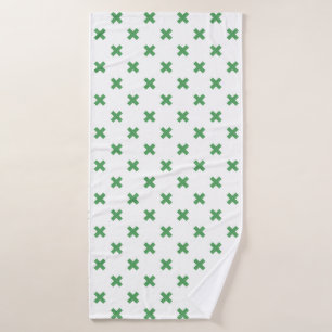 Green cross stitches on white bath towel