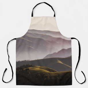 GREEN GRASS FIELD AND MOUNTAINS DURING DAYTIME APRON
