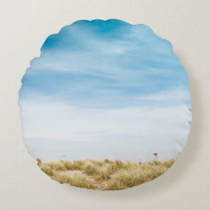 Green grass field under blue skies round pillow