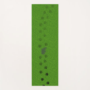 Green grass with dog paw prints and a pee stain yoga mat