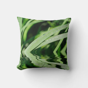 Green grass with drops of dew reflecting in water throw pillow