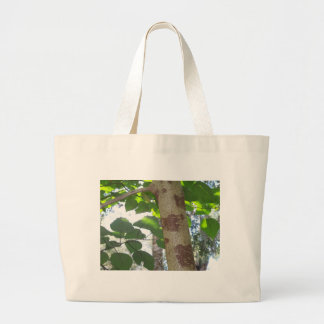 green leaves and tree trunk with cool bark large tote bag