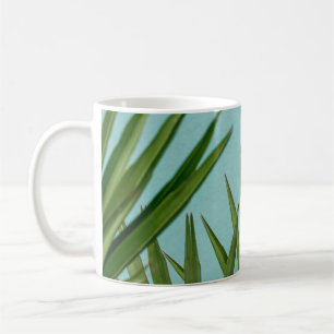 Green palm plant near body of water coffee mug
