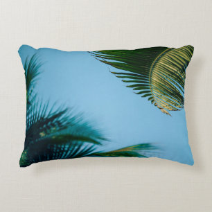 Green palm tree under blue sky in the morning accent pillow