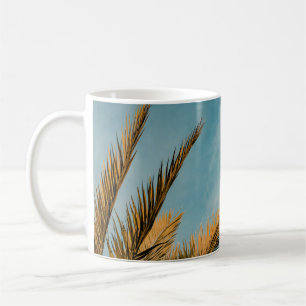 Green palm tree under blue sky in the morning coffee mug