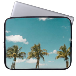 Green palm tree under blue sky in the morning laptop sleeve