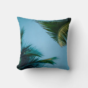 Green palm tree under blue sky in the morning throw pillow