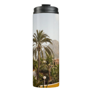 Green palm trees near brown concrete building in t thermal tumbler