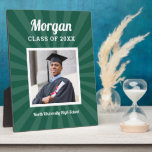Green Sunburst Graduation Party Photo Plaque<br><div class="desc">Vibrant green sunburst rays set an energetic tone behind a custom graduation portrait. The graduate's name appears in flowing script above bold class year text,  with the school name below for a spirited keepsake celebrating their accomplishment. Photo and all text fields are customizable.</div>