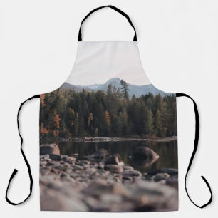 GREEN TREES REFLECTION ON BODY OF WATER DURING DAY APRON