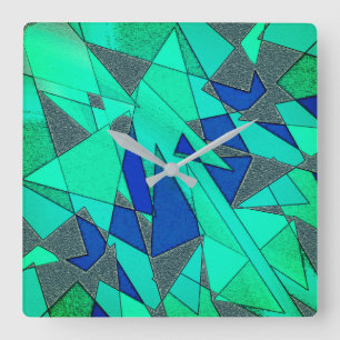 Green triangular cutouts on blue background, rough square wall clock