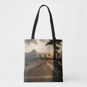 Grey asphalt road near mountain in the morning tote bag