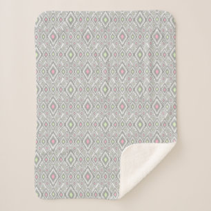 Grey, green, pink rhombuses on a white sherpa blanket