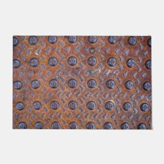 Grille âgée en métal dans le vieux tapis de porte