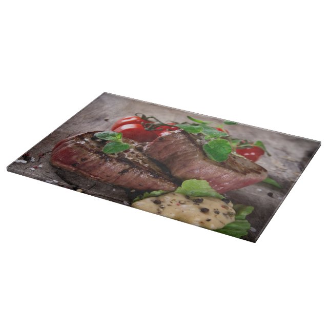 Grilled bbq steaks with fresh herbs and tomatoes cutting board (Corner)