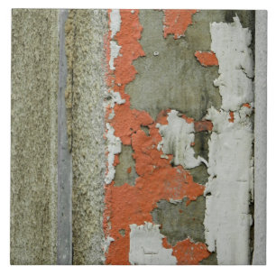 Grunge peeling orange paint on concrete wall tile