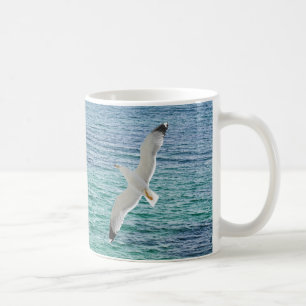 Gull flying above a sea coffee mug