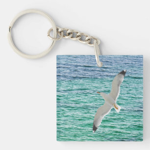 Gull flying above a sea keychain