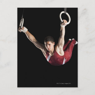 Gymnast swinging from rings postcard