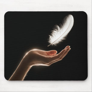 Hand Releasing a White Feather Mouse Pad