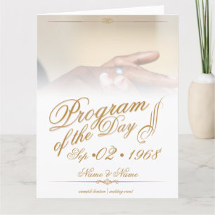 Hands of a coloured wedding couple pin on ring gol thank you card