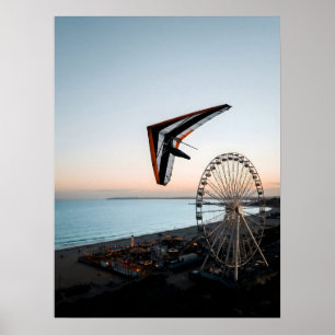 Hang Glider Soaring Over Coastal Ferris Wheel Poster