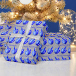 Hanukkah Dreidels Blue Pattern Personalize This Wrapping Paper<br><div class="desc">Dancing Dreidels in blue form a cheerful pattern on this Hanukkah wrapping paper perfect for kids or adults. Unwrap eight nights of Chanukah fun with bold colours of blue, white and silver with two spaces for your own text, which can also be deleted for Dreidel only gift wrap. Personalize each...</div>