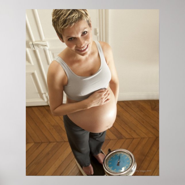 Happy pregnant woman standing on scale poster (Front)