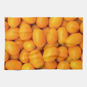 Heap of orange kumquats in cardboard box kitchen towel