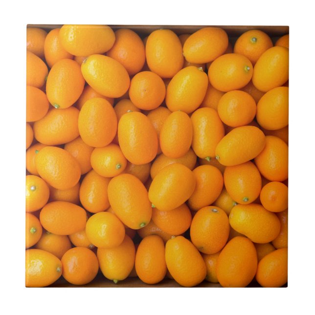 Heap of orange kumquats in cardboard box tile (Front)
