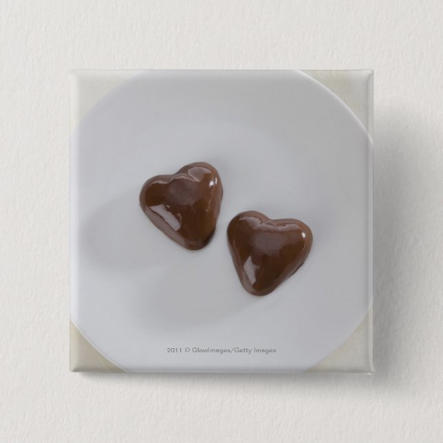 Heart shaped chocolate candies on a plate 2 inch square button (Front)