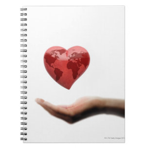 Heart with global map over female hand notebook