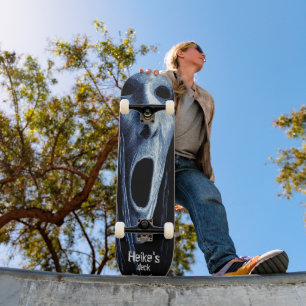 Hollow-eyed phantom witch etching on blue-black skateboard