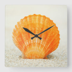 Horloge Carrée Feston Shell orange se tenant droit en sable