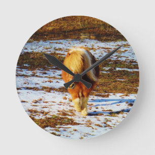 Horloge Ronde Cheval miniature brun et crème dans la neige.