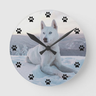 Horloge Ronde Enchanter White Husky Dog dans la neige Pawprint