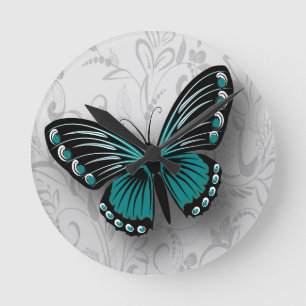 Horloge Ronde Papillon Turquoise géant sur la flore grise