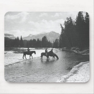 Horses drinking from and crossing a river mouse pad