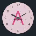 Hot Pink Modern Script Girly Monogram Name Large Clock<br><div class="desc">A striking blend of style and functionality, this personalized clock features a bold, hot pink monogram set against a soft pink background, showcasing an elegant, handwritten script for the name. The minimalist design balances vibrant modernity with a touch of femininity, making it a standout piece for any room that calls...</div>